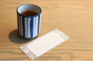 湯飲み茶わんに入ったお茶とおしぼり