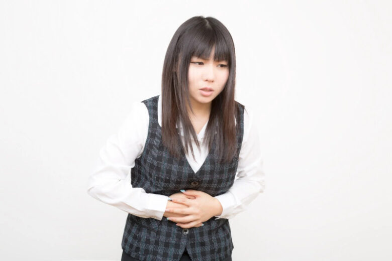 ココアの飲み過ぎで腹痛を感じている女性の写真
