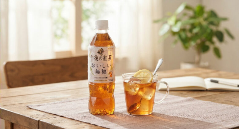 木目のテーブルの上に置かれた「午後の紅茶 おいしい無糖」のペットボトルと、レモンの添えられたアイスティーのグラス