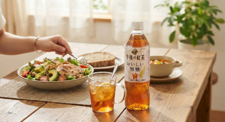 健康的なサラダやパンが並ぶ食卓に置かれた「午後の紅茶 おいしい無糖」のペットボトルとグラス