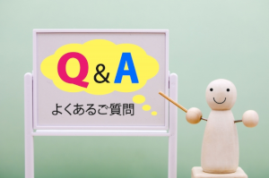 Q&Aよくある質問と書かれた小さなホワイトボードと木の人形