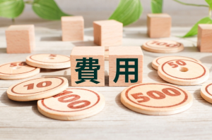 費用と書かれた2つの積木とおもちゃのお金が数枚