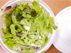 サラダスピナーに入れられた緑の野菜

