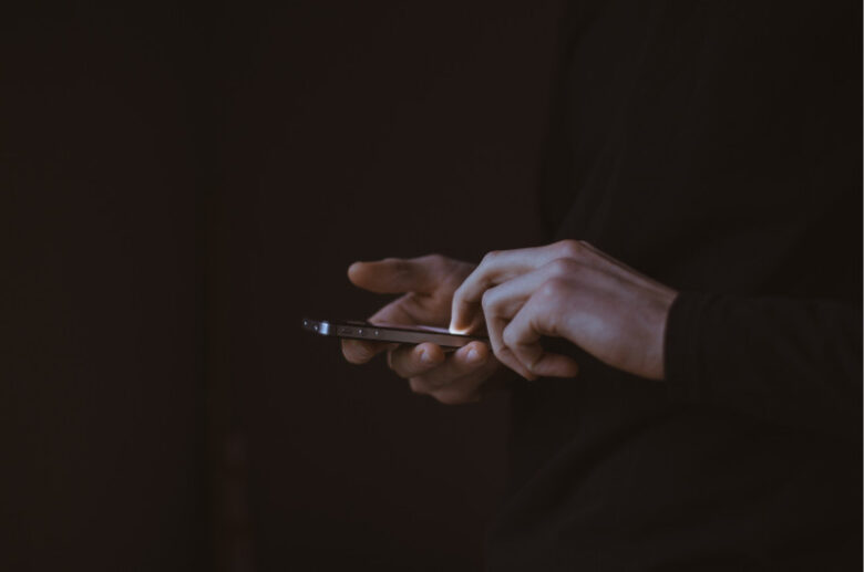 スマートフォンを操作する手元。コート外でも現代的で洗練されたスタイルを貫くアスリートの日常的な一面