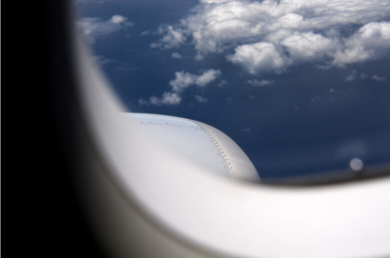飛行機の窓から見える雲と空の風景。新たな出発をイメージした空の旅